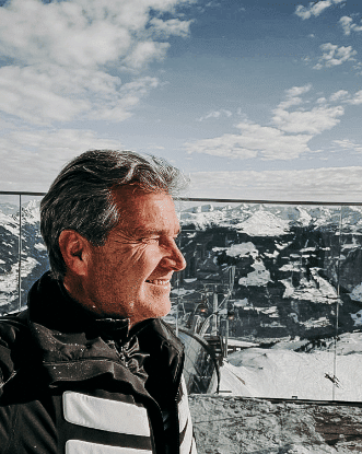 Heinz vom Boutiquehotel Haidachhof vor schneebdeckten Bergen