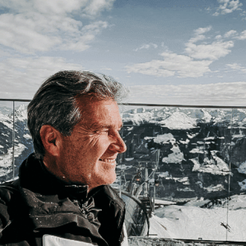 Heinz vom Boutiquehotel Haidachhof vor schneebdeckten Bergen