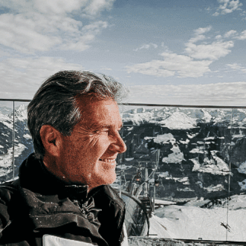 Heinz vom Boutiquehotel Haidachhof vor schneebdeckten Bergen