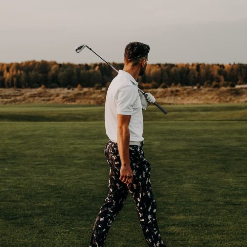 Golfer mit Schläger schlendert über den Golfplatz